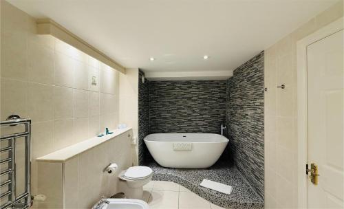 a bathroom with a white tub and a toilet at Hustyns Hotel in Wadebridge