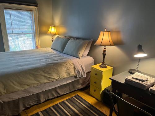 a bedroom with a bed with a lamp and a desk at Slumberland at the River's Edge in Pond Eddy