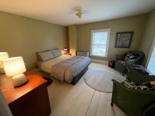a bedroom with a bed and a table and chairs at Slumberland at the River's Edge in Pond Eddy