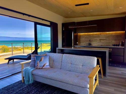 a living room with a couch and a view of the ocean at Luxury Absolute Ocean View Lodge in Waverley