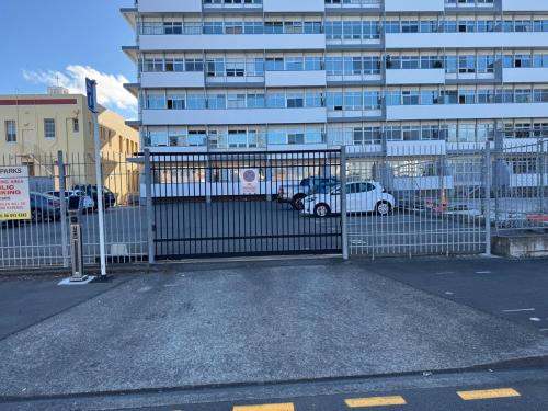 a gate in front of a large building with cars at Chic apartment in Art Deco Napier in Napier