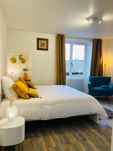 - une chambre avec un grand lit blanc et une chaise bleue dans l'établissement Beau studio proche des Halles, à Crémieu