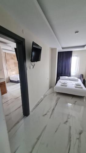 a bedroom with a bed and a tv on the wall at Bianco Beach Hotel in Kusadası