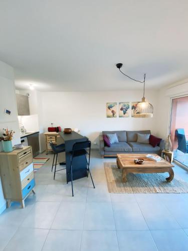 un salon avec un canapé et une table dans l'établissement Appartement Sierra - Tram A - Free Parking - Free WIFI, à Cenon