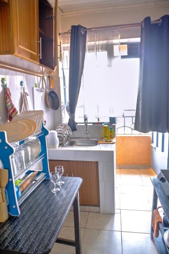 a small kitchen with a sink and a table at Cozy Haven in Juja