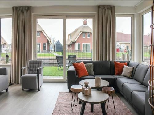a living room with a couch and a large window at Villa in Friesland with Waterfront Jetty in Idskenhuizen