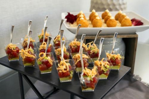 a table with a bunch of appetizers in plastic cups at Torrance Marriott Redondo Beach in Torrance