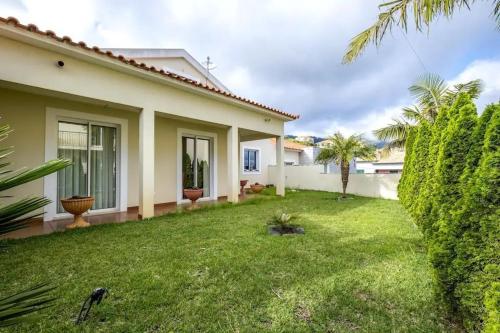 a backyard of a house with a grass yard at Villa Pita in Relógio do Poiso