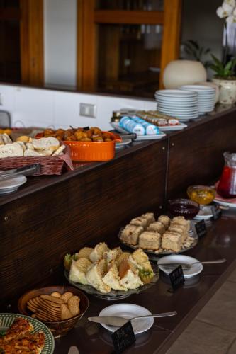 a buffet line with many different types of food at Hotel Le Renard - Campos do Jordao in Campos do Jordão