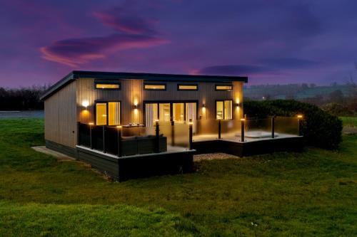 a tiny house in a field at night at Mallards Rest - Countryside Hot Tub in Narberth