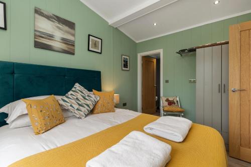 a bedroom with a large bed with green walls at Mallards Rest - Countryside Hot Tub in Narberth