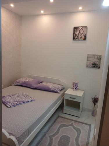 a small bedroom with a bed and a table at Apartmani LaVa igalo 1 in Igalo
