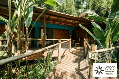 a wooden walkway leading to a house with a porch at Banana Bamboo Ecolodge in Ubatuba