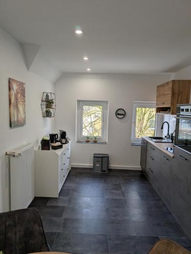 a kitchen with white cabinets and a tile floor at Villa Baumhaus Apartments in Hamm