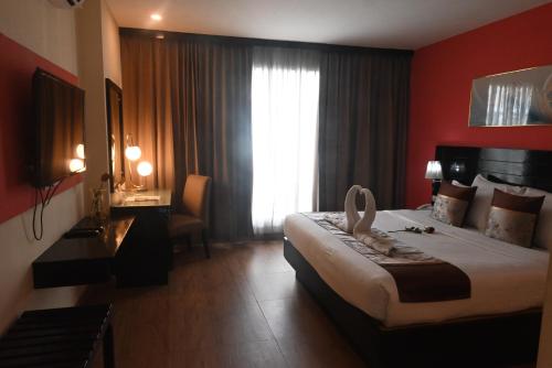 Ένα ή περισσότερα κρεβάτια σε δωμάτιο στο Boss Suites Nana Hotel