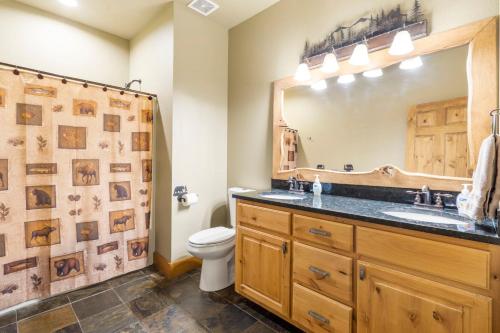 a bathroom with a sink and a toilet and a mirror at Luxury Lakefront Chalet Resort 2 Pools FREE Amenities Dock MiniGolf Waterslide in Lampe