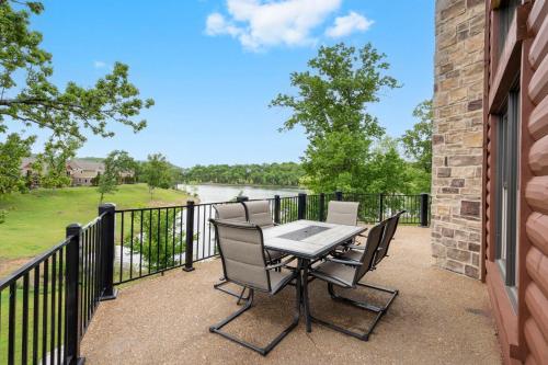 a patio with a table and chairs on a balcony at Luxury Lakefront Chalet Resort 2 Pools FREE Amenities Dock MiniGolf Waterslide in Lampe