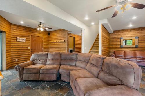 a living room with a brown leather couch at Luxury Lakefront Chalet Resort 2 Pools FREE Amenities Dock MiniGolf Waterslide in Lampe