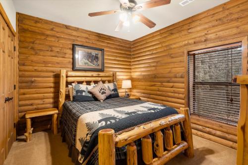 a log cabin bedroom with a bed and a ceiling fan at Luxury Lakefront Chalet Resort 2 Pools FREE Amenities Dock MiniGolf Waterslide in Lampe