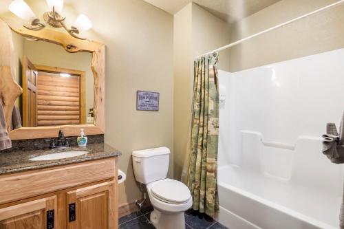 a bathroom with a toilet and a sink and a tub at Luxury Lakefront Chalet Resort 2 Pools FREE Amenities Dock MiniGolf Waterslide in Lampe