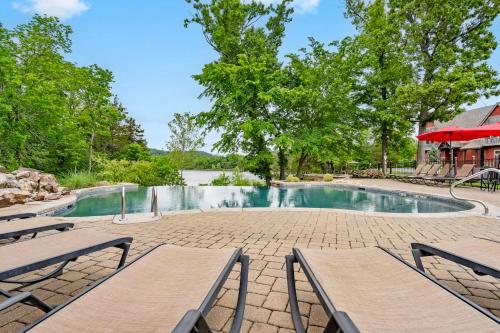 a swimming pool with two picnic tables and chairs at Luxury Lakefront Chalet Resort 2 Pools FREE Amenities Dock MiniGolf Waterslide in Lampe