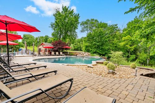 a swimming pool with lounge chairs and umbrellas at Luxury Lakefront Chalet Resort 2 Pools FREE Amenities Dock MiniGolf Waterslide in Lampe