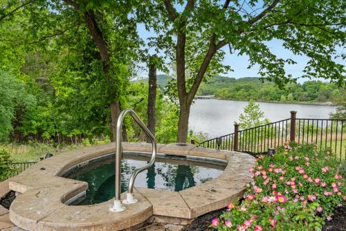 a hot tub in a garden with a view of a lake at Luxury Lakefront Chalet Resort 2 Pools FREE Amenities Dock MiniGolf Waterslide in Lampe