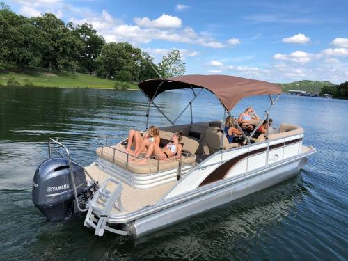 a group of people sitting on a boat on the water at Luxury Lakefront Chalet Resort 2 Pools FREE Amenities Dock Kayaks Waterslide in Lampe