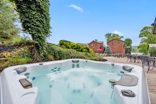 a jacuzzi tub in a yard with a patio at Luxury Lakefront Chalet Resort 2 Pools FREE Amenities Dock Kayaks Waterslide in Lampe