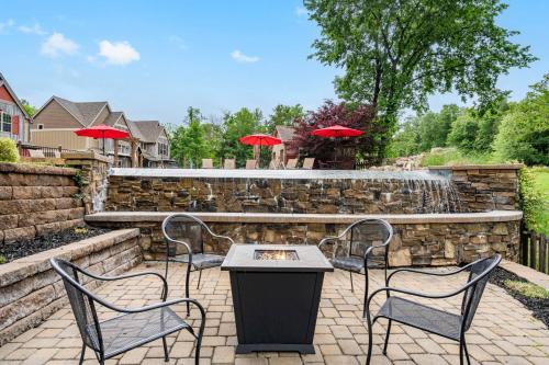 a patio with three chairs and a table and a fountain at Luxury Lakefront Chalet Resort 2 Pools FREE Amenities Dock Kayaks Waterslide in Lampe