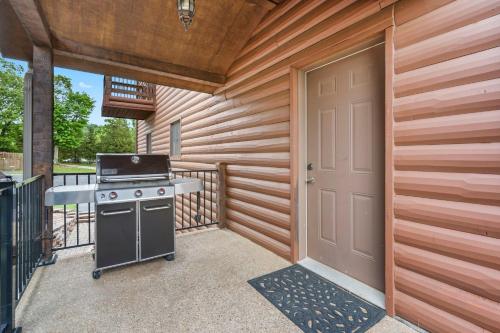 a patio with a grill and a door to a house at Luxury Lakefront Chalet Resort 2 Pools FREE Amenities Dock Kayaks Waterslide in Lampe