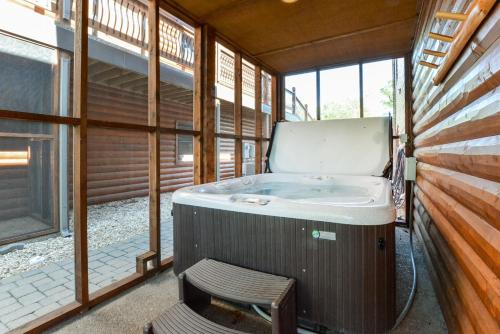 a bath tub in a room with a chair and windows at Luxury Lakefront Chalet Resort 2 Pools FREE Amenities Dock Kayaks Waterslide in Lampe