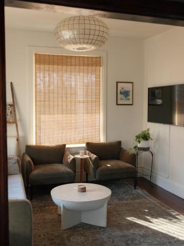 a living room with two couches and a coffee table at Designer Home, Hot Tub, Private Yard, & Projector in Hudson