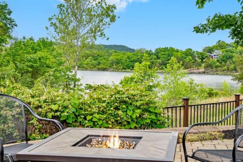 a fire pit on a patio with a view of a river at Luxury Lakefront Chalet Resort 2 Pools FREE Amenities Dock Kayaks Waterslide in Lampe