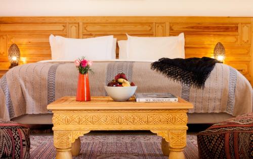 a bed with a table with a bowl of fruit on it at Riad Sougtani in Marrakech
