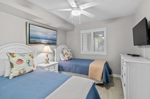 a bedroom with two beds and a ceiling fan at Beach and Golf Oceanfront 3 Bdrm Newly Renovated in Pawleys Island