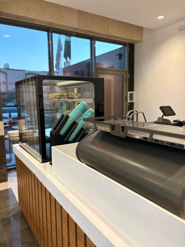 a bakery with a machine with donuts on a counter at Doyof Hotel فندق ضيوف in Al Madinah