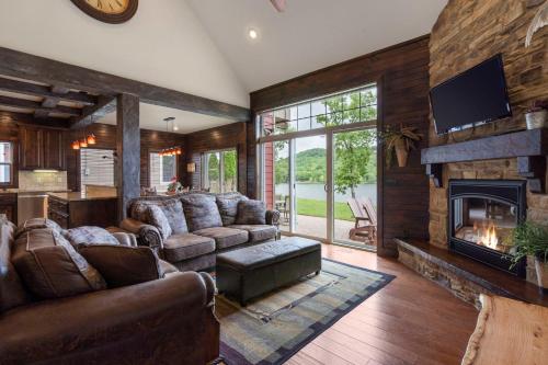 a living room with leather furniture and a fireplace at Chalets Resort Luxury Lakefront Villa Amazing View 2 Pools Free Amenities Dock in Lampe