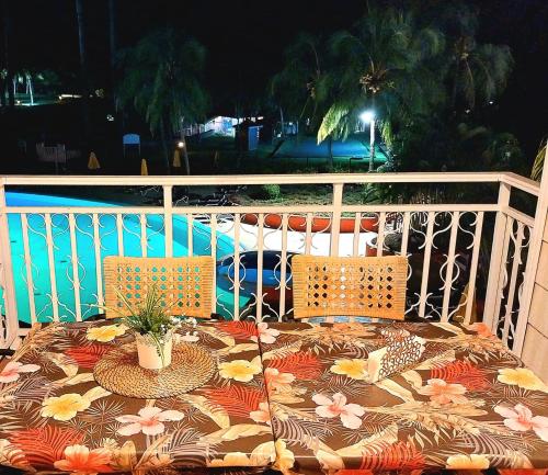 a table with two chairs on a balcony at Résidence au cœur des îles Martinique 23 in Bellevue