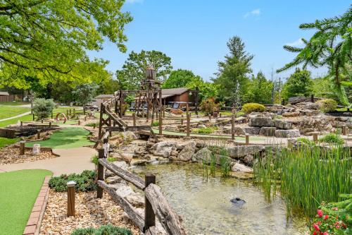 a garden with a pond and a playground at 8 Bed Luxury Lakefront Villa Amazing View 2 Pools Free Resort Amenities Dock in Lampe