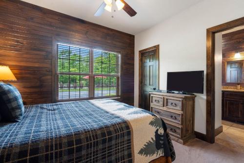 a bedroom with a bed and a flat screen tv at Chalets Resort Luxury Lakefront Villa Amazing View 2 Pools Free Amenities Dock in Lampe