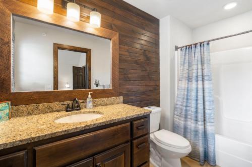 a bathroom with a sink and a toilet and a mirror at Chalets Resort Luxury Lakefront Villa Amazing View 2 Pools Free Amenities Dock in Lampe