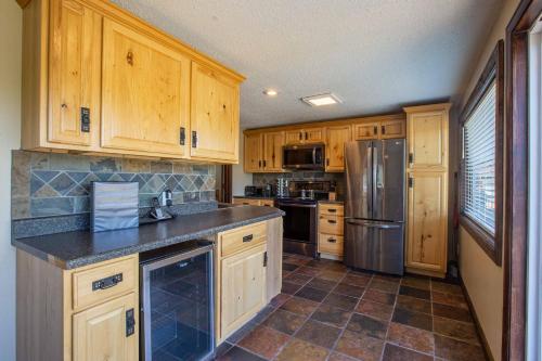 a kitchen with wooden cabinets and a stainless steel refrigerator at Chalets Resort LAKEFRONT Cottage Free Amenities Amazing views Kayaks 2 Pools in Lampe