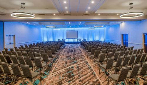 an empty room with chairs and a screen at Staybridge Suites Oxnard - River Ridge by IHG in Oxnard