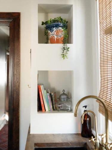 a kitchen with a sink and a shelf with books at Designer Home, Hot Tub, Private Yard, & Projector in Hudson