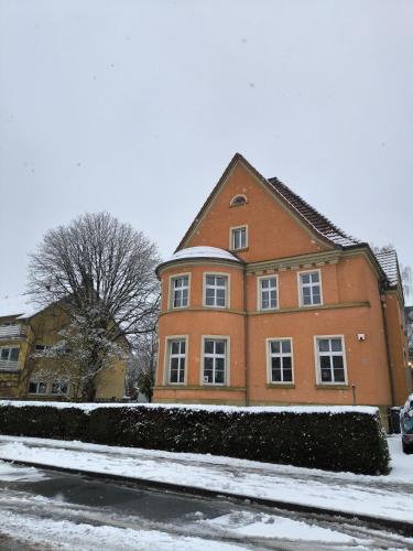 a large brick house with snow on the ground at Villa Baumhaus Apartments in Hamm