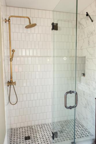 a bathroom with a shower with a glass door at Designer Home, Hot Tub, Private Yard, & Projector in Hudson