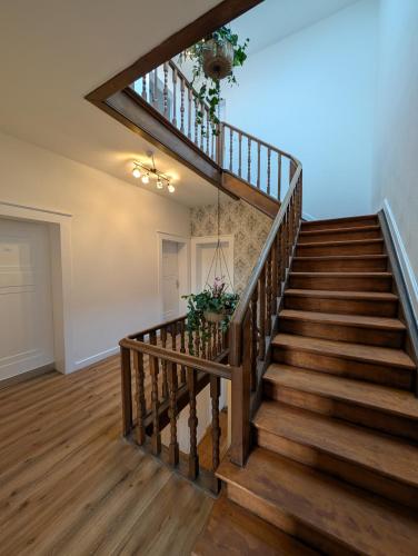 a staircase in a home with wooden floors at Villa Baumhaus Apartments in Hamm