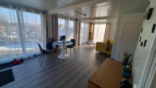 a living room with a table and chairs and a large window at Konténer kulcsosház in Fîntînele