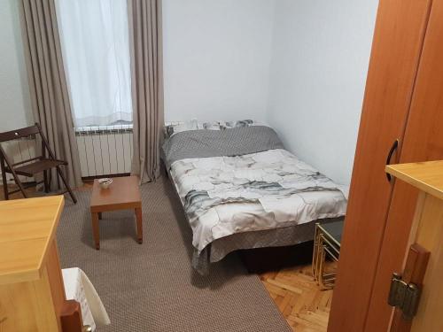a small bedroom with a bed and a table at Ozon in Belgrade